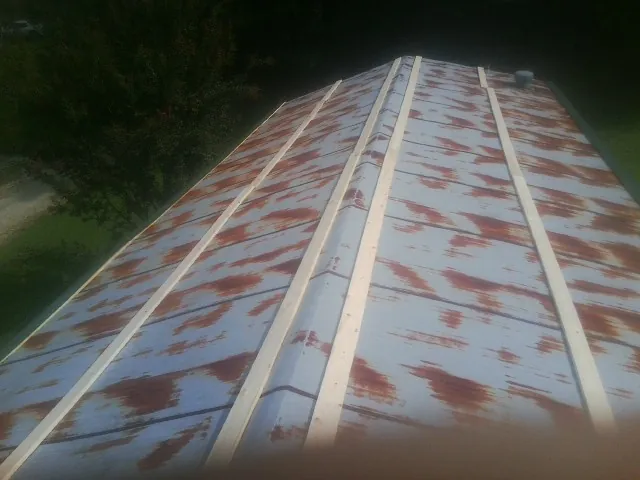 Rusted metal roof panels with new wood purlins before replacement — Storm Damage Roof Repair in Novi by Roofing Brothers