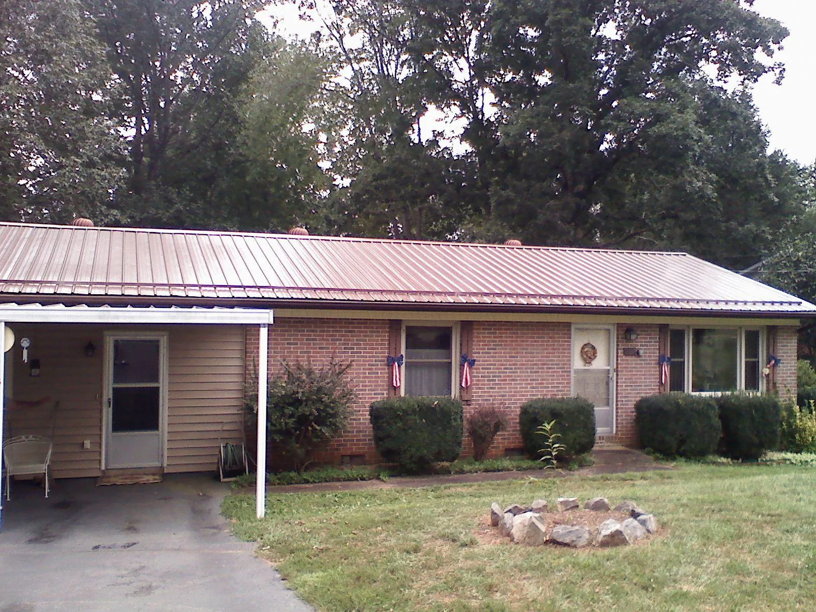 Bronze metal roof and carport on a brick ranch home in Novi